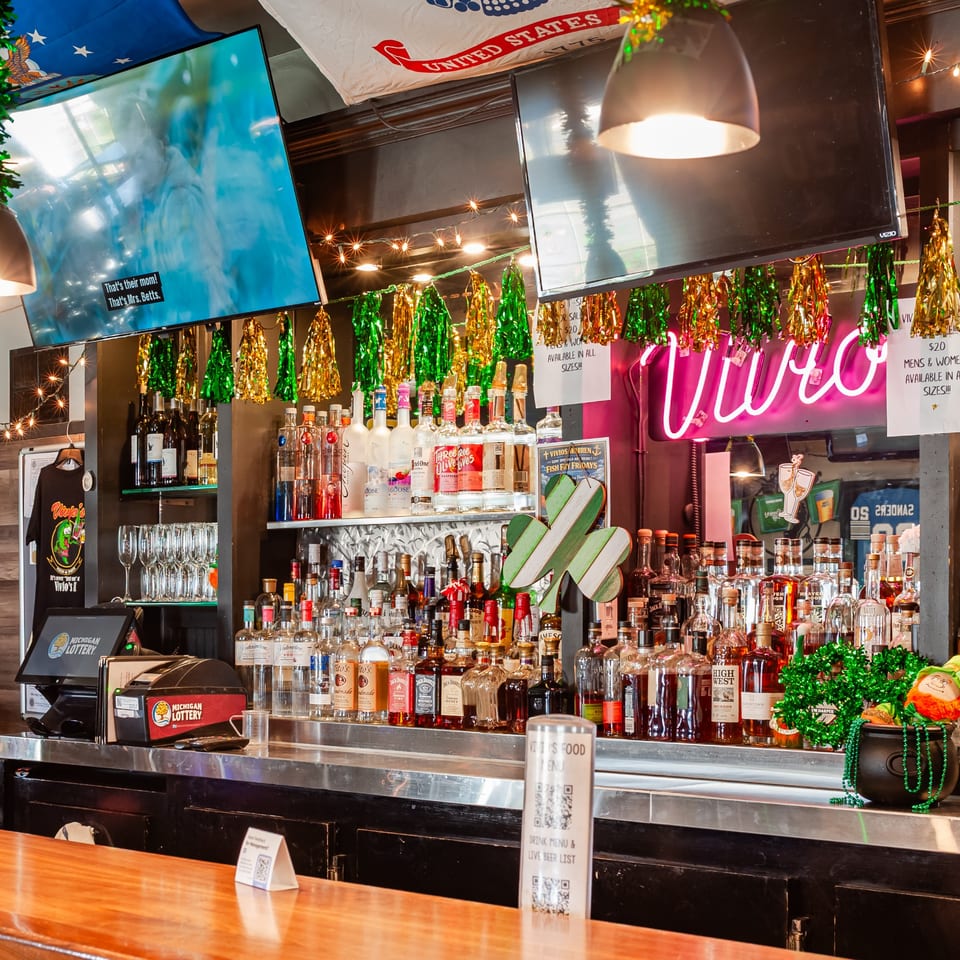 Vivio's II bar with various liquor bottles, TVs, and St. Patrick's Day decorations.