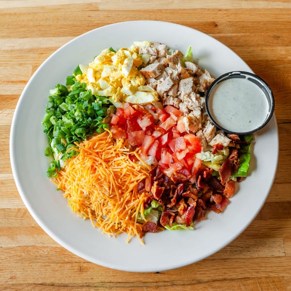 A Vivio's II diner salad with chicken, bacon, cheese, tomatoes, eggs, and green onions.