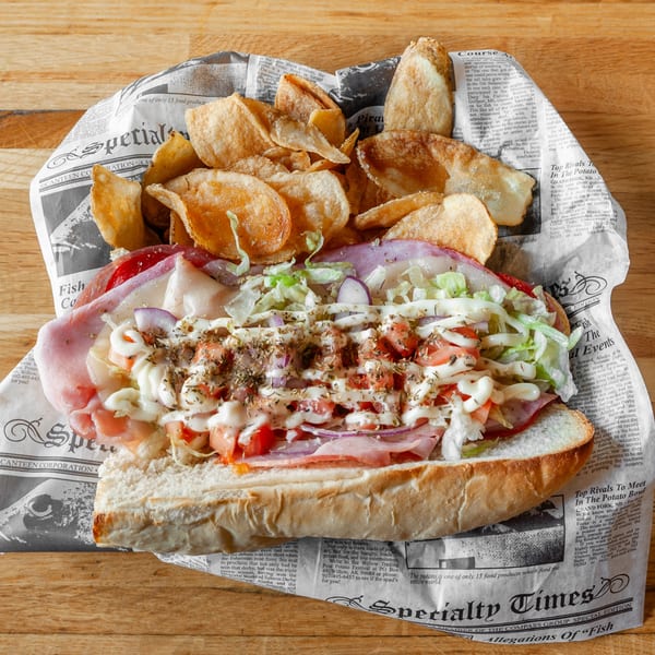 A Vivio's II Food & Spirits sub sandwich with meat, cheese, lettuce, tomato, and chips.