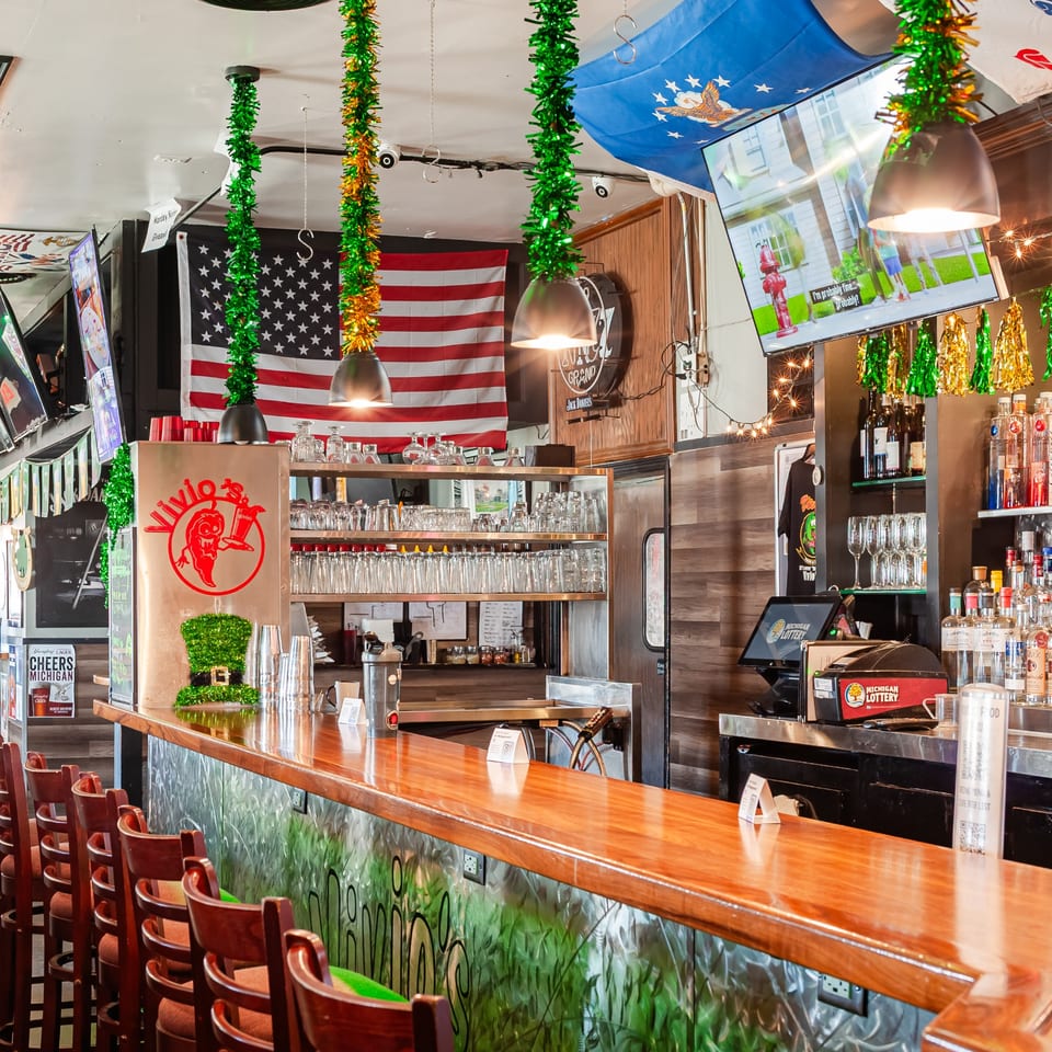 Vivio's II bar with St. Patrick's Day decorations, American flag, and Michigan Lottery machine.